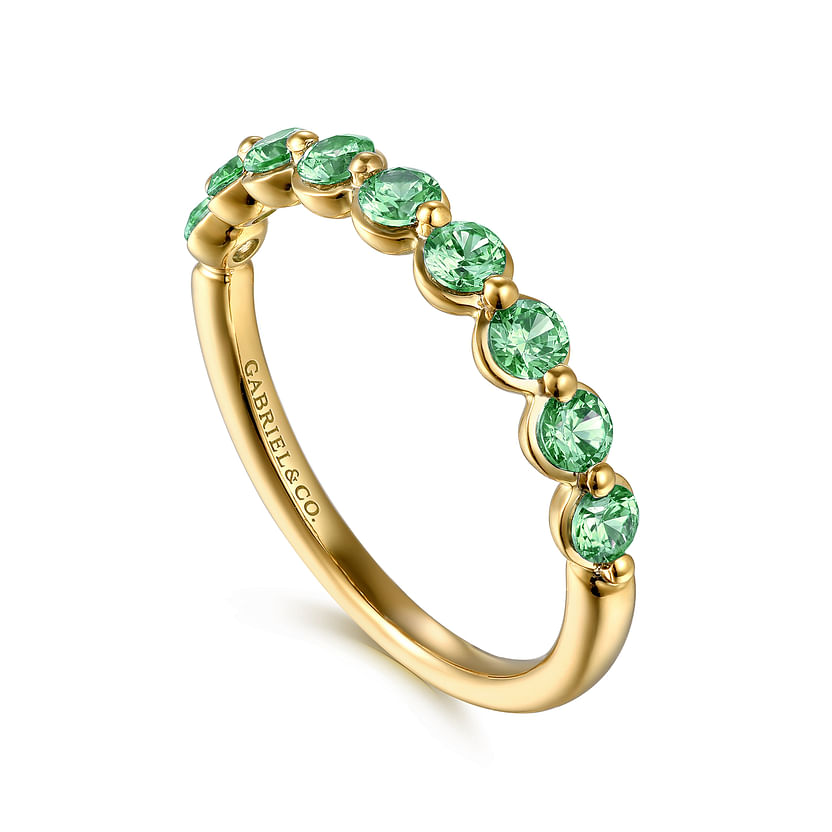 The 14K Yellow Gold Emerald Stackable Ring by Gabriel & Co features eight round green gemstones in a row with "GABRIEL & CO." engraved inside, offering an elegant, minimalistic design ideal as a May birthstone piece.