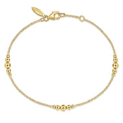 The Gabriel & Co 14K Yellow Gold Graduating Bead Stations Bracelet features evenly spaced gold beads on a delicate chain with a lobster clasp closure and small tag.