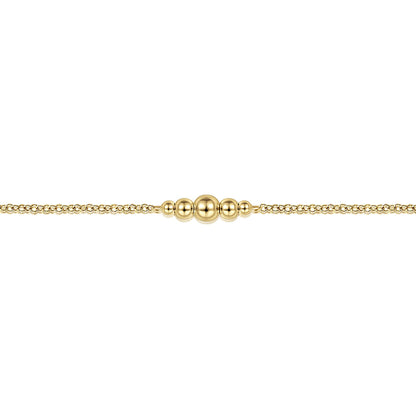 The Gabriel & Co 14K Yellow Gold Graduating Bead Stations Bracelet features five polished beads in a row, decreasing in size from the center outward—perfect for stacking and shown against a white background.