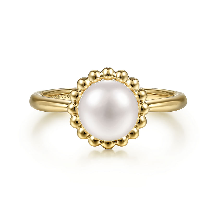 The Gabriel & Co 14K Yellow Gold Pearl Ring showcases a central round white pearl, surrounded by a decorative beaded halo and set against a white background.