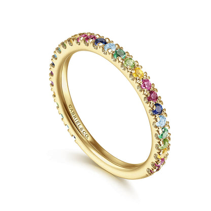 The Gabriel & Co 14K Yellow Gold Rainbow Color Stone Stackable Ring features a slim band set with round pink, blue, green, and yellow stones. "CARAT & CO." is engraved inside—perfect for stacking in vibrant style.