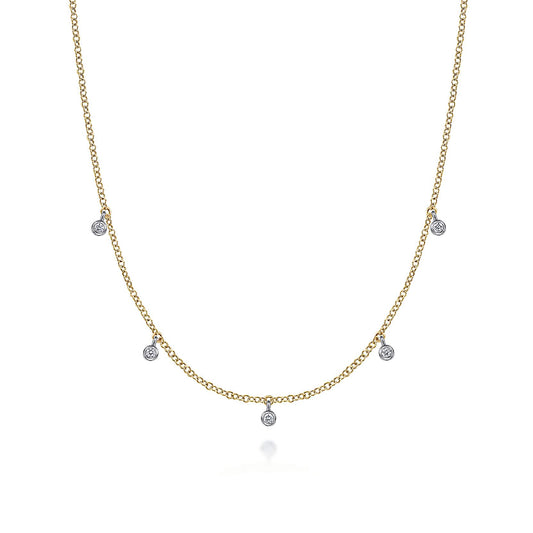 The Gabriel & Co 14K Yellow-White Gold Diamond Stations Droplet Necklace from the Contemporary Collection features five small round diamond pendants spaced along a delicate chain, shown on a white background.