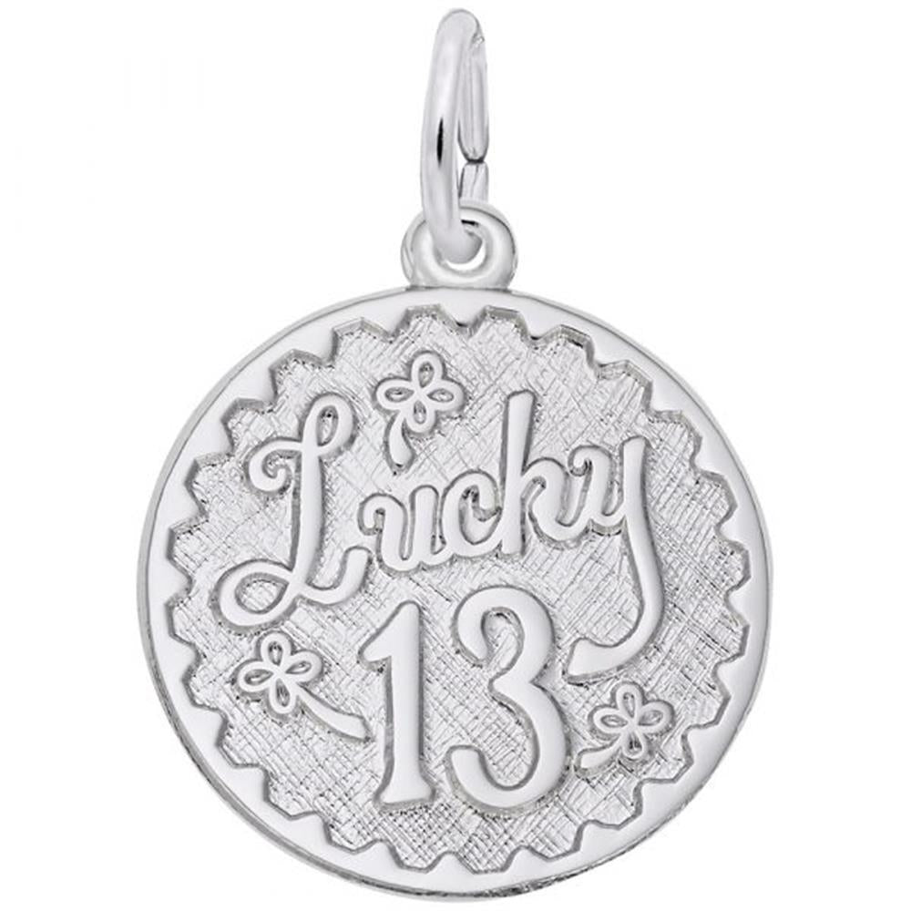 The Lucky 13 Charm by Rembrandt Charms is a sterling silver, round pendant showcasing the word "Lucky" in cursive script above the number "13". The charm features a scalloped edge and is adorned with small flower designs around the text. It includes a small silver loop at the top for hanging.