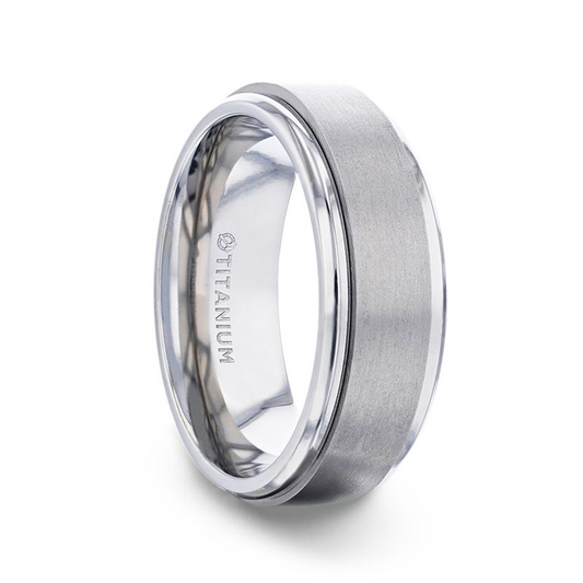 The REBELLION Spinning Brushed Center Titanium Ring by Thorsten showcases a polished titanium band with a spinning brushed center and gleaming beveled edges. The interior of the 8mm band is shiny and engraved with "TITANIUM." This ring captures a modern, sleek design ideal for those who value both style and a touch of rebellion.