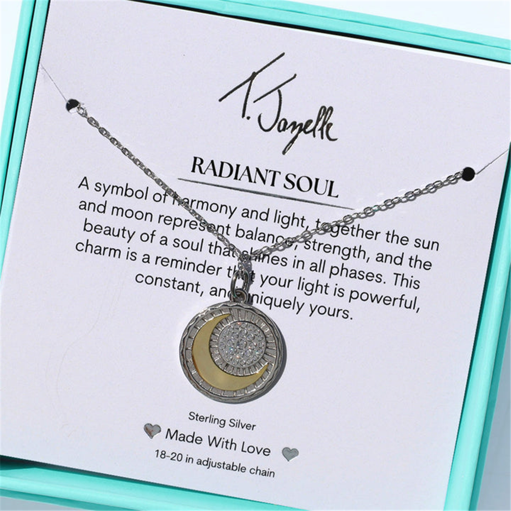 The T Jazelle Radiant Soul Sterling Silver Charm Necklace features a circular pendant with a crescent moon and sparkling center, presented in a turquoise box with a "RADIANT SOUL" card explaining its sun and moon symbolism.
