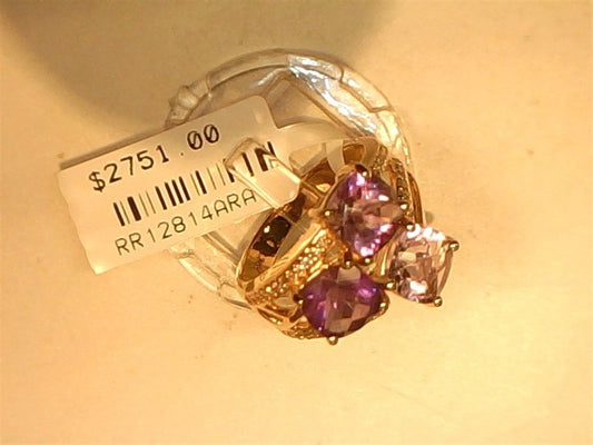 The Ryan Gems Mixed Amethyst bubble ring in 14k rose gold, size 6.75, features two large square-cut amethysts and accent stones. Displayed on a clear stand, it’s priced at $2751.00 (code: RR12814RRA).