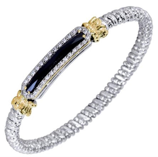 Introducing the Alwand Vahan Jewelry bracelet: an exquisite sterling silver coiled piece featuring a central elongated black onyx gemstone set horizontally. The 4mm band is adorned with small, clear 0.23ct diamonds and accented by intricate 14k gold-colored details on either side. This bracelet boasts a beautifully textured, twisting design that showcases the craftsmanship of Alwand Vahan Jewelry.
