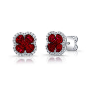 The 18K White Gold Clover Shaped Ruby and Diamond Outline Stud Earrings by Uneek Jewelry boast an elegant design with a four-petaled flower-like shape, featuring vibrant red rubies at the center and surrounded by a halo of sparkling clear diamonds. The earrings are set in 18K white gold and feature a push-back closure.