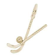 The Field Hockey Charm by Rembrandt Charms is a gold-plated sterling silver piece featuring two crossed hockey sticks with a textured hockey puck positioned between them. Ideal for field hockey enthusiasts, it includes a loop at the top for attaching to a necklace or bracelet.