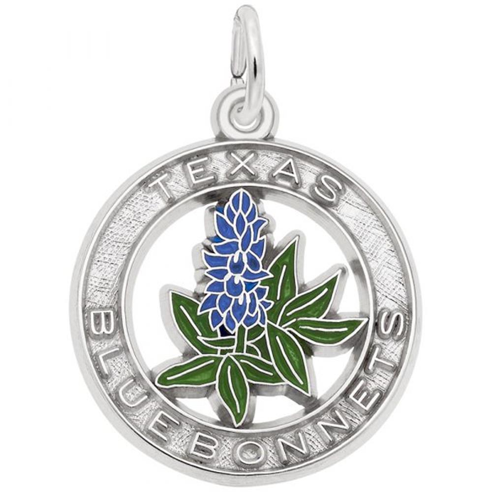 The Rembrandt Charms Texas Bluebonnets Charm is crafted from sterling silver and features a circular design. The words "Texas Blue Bonnets" are inscribed around the edge, while an enamel depiction of a bluebonnet flower with green leaves and blue petals adorns the center. A small loop at the top allows for easy attachment to a chain.