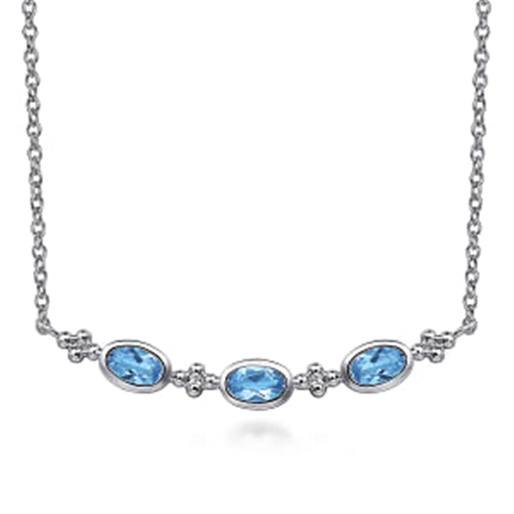 The Gabriel & Co 925 Sterling Silver Bujukan Blue Topaz Bar Necklace (Serial No: S174) features a delicate arrangement of three Swiss Blue Topaz gemstones positioned horizontally. Small silver accents are set between each gemstone, all gracefully displayed on a fine 925 Sterling Silver chain. This exquisite piece embodies the elegance and craftsmanship associated with the Gabriel & Co brand.