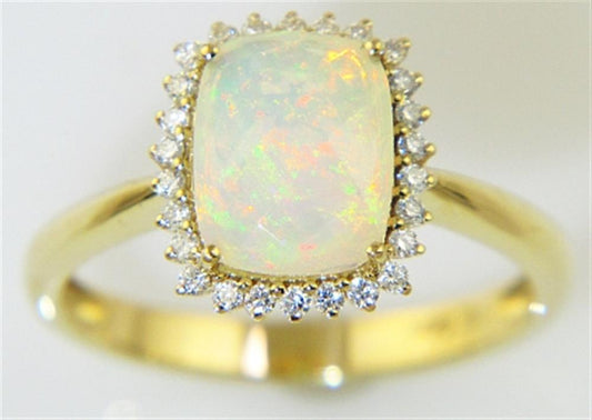 Introducing the Bellarri Faceted Opal and Diamond Ring from the Forever Young Collection: a stunning gold ring featuring a large, rectangular cushion-cut opal gemstone with 1.33 carats, surrounded by a dazzling halo of 0.17 carats of small diamonds. The opal exhibits an enchanting play of colors with vibrant flashes of green, orange, and yellow. The polished 14K yellow gold band completes this captivating piece.
