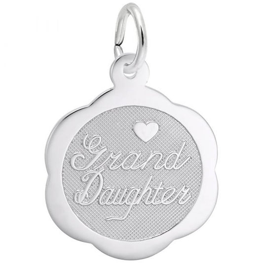 The Rembrandt Charms "Granddaughter Scalloped Disc Charm" in sterling silver is beautifully crafted to resemble a rounded flower. It is inscribed with the words "Grand Daughter" and features a textured background at the center with a small heart positioned above the text. A loop at the top allows for easy hanging or threading onto a chain, making it an ideal gift for your beloved granddaughter.