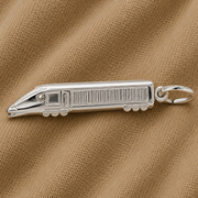 The Rembrandt Charms Eurotrain Charm—crafted in sterling silver and featuring detailed windows and wheels—rests on a textured light brown fabric background.