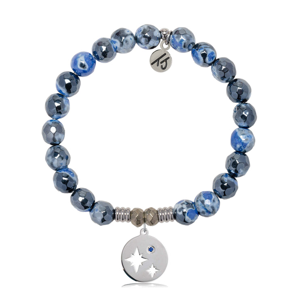 The T Jazelle Denim Blue Agate Gemstone Bracelet features denim blue agate and silver marbled beads, sterling silver mother-son charm with star cutouts and blue gem, plus a small engraved initials tag near the clasp.