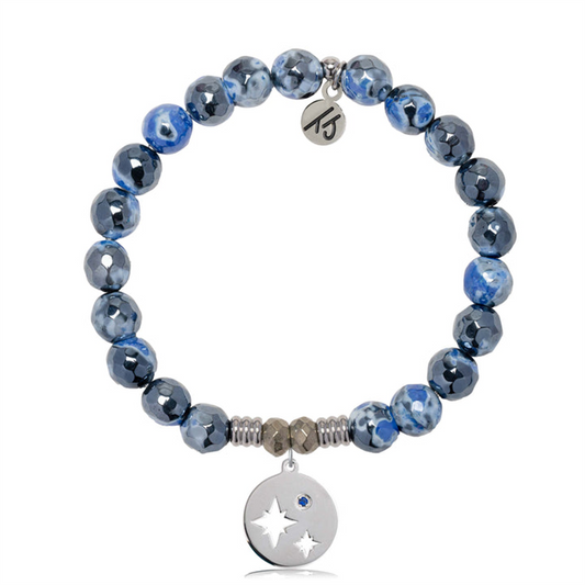 The T Jazelle Denim Blue Agate Gemstone Bracelet features denim blue agate and silver marbled beads, sterling silver mother-son charm with star cutouts and blue gem, plus a small engraved initials tag near the clasp.