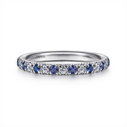 The 14K White Gold Diamond & Sapphire Anniversary Band by Gabriel & Co features alternating blue sapphires and white diamonds in a continuous loop. Stackable with other rings, it is engraved with branding on the interior and boasts a polished finish.