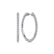 A pair of 30mm Sterling Silver Bujukan Classic Hoop Earrings from Gabriel & Co. The classic hoops feature a continuous pattern of spherical beads, creating a textured appearance. One earring is shown front-facing while the other displays its side profile against a white and minimalistic background.