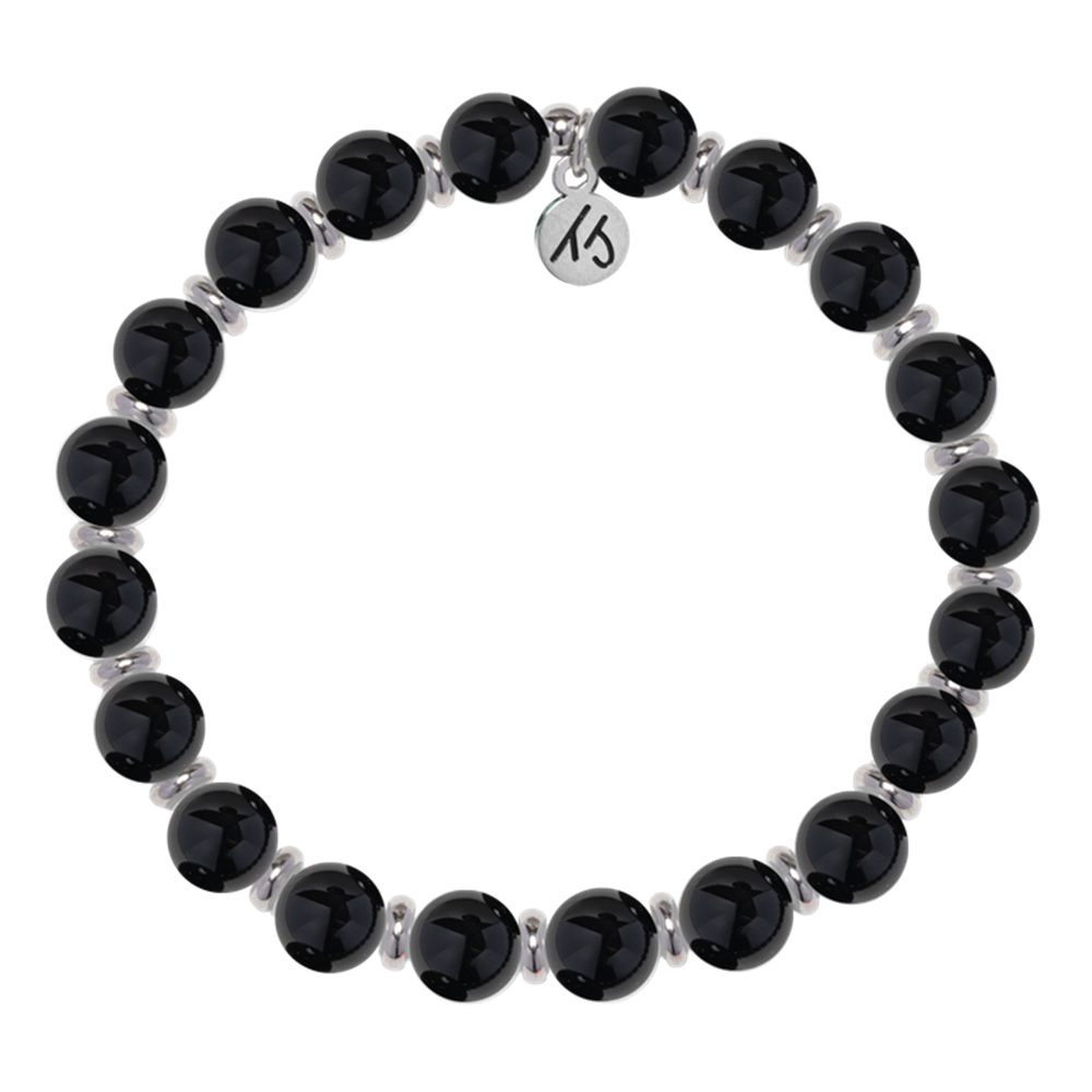 The T Jazelle Silver Empowered Elegance Collection Onyx Gemstone Bracelet features shiny black round beads with silver spacers and a silver engraved charm, arranged in a circle on a white background.