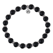 The T Jazelle Silver Empowered Elegance Collection Onyx Gemstone Bracelet features shiny black round beads with silver spacers and a silver engraved charm, arranged in a circle on a white background.