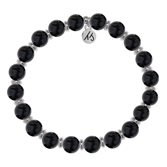 The T Jazelle Silver Empowered Elegance Collection Onyx Gemstone Bracelet features shiny black round beads with silver spacers and a silver engraved charm, arranged in a circle on a white background.