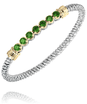 A sterling silver and 14k gold bracelet by Alwand Vahan Jewelry, highlighted with a beaded texture throughout, featuring seven round green gemstones, each set in a delicate gold setting.