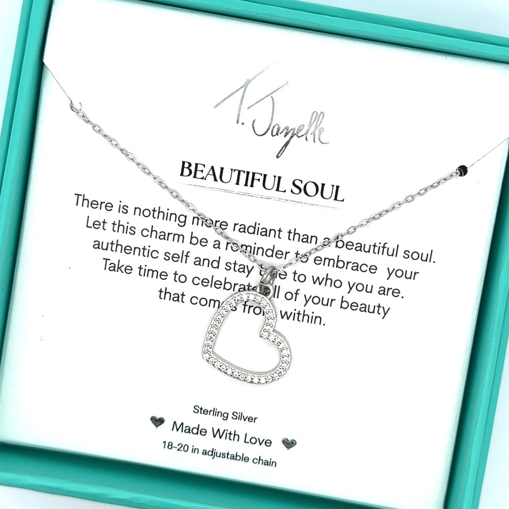 The T Jazelle Beautiful Soul Sterling Silver Charm Necklace features a silver heart-shaped pendant with crystals on a chain, beautifully presented in a turquoise box with a card reading “BEAUTIFUL SOUL” and an uplifting message about inner beauty.