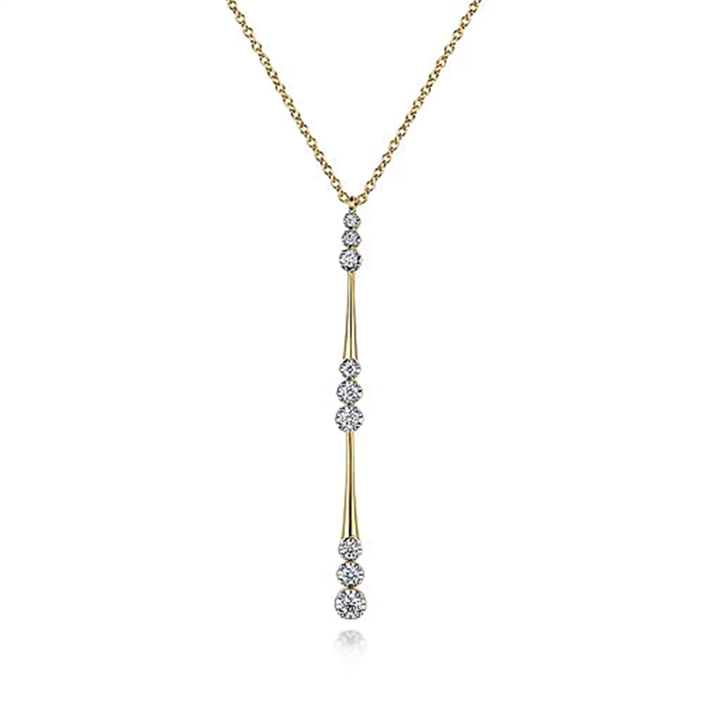 The Gabriel & Co. 14K Yellow Gold Graduated Diamond Station Drop Y Necklace features a delicate design with round white diamonds set in a vertical line in a drop pendant style. The evenly spaced diamonds along the vertical drop create an elegant, modern look, complemented by the fine, simple link chain.