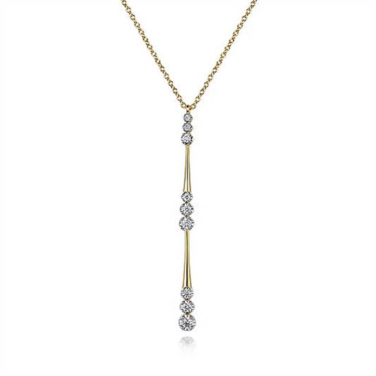 The Gabriel & Co. 14K Yellow Gold Graduated Diamond Station Drop Y Necklace features a delicate design with round white diamonds set in a vertical line in a drop pendant style. The evenly spaced diamonds along the vertical drop create an elegant, modern look, complemented by the fine, simple link chain.