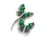 This Green Tsavorite and Diamonds Butterfly Ring from Bellarri features two intricately designed butterfly motifs adorned with dark gemstones. The wings of each butterfly are accentuated with clear, shimmering crystals. This exquisite piece complements a 14K white gold necklace when displayed against a plain white background.