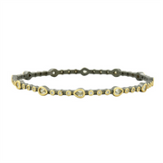 The Freida Rothman Signature Two-Tone Pavé Thin Hinge Bangle is an elegant 14K matte gold bangle with oval and circular settings, each featuring a lab-created diamond simulant, in a minimalist design with gemstones evenly distributed.