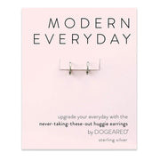 A product card with the heading "Modern Everyday - Earring SS" displays a pair of small, silver huggie earrings attached to the card. The text below reads, "Upgrade your everyday look with the never-taking-these-out huggie earrings by Dogeared.