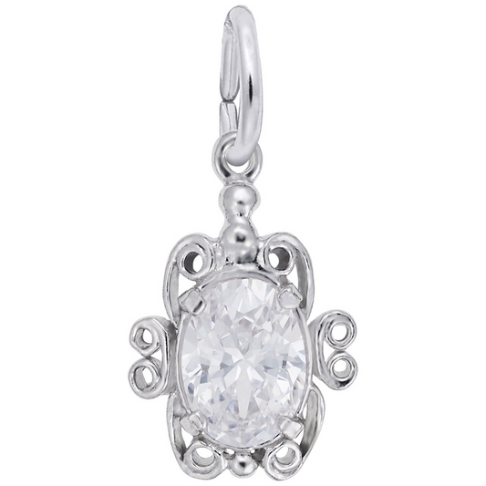 The Rembrandt Charms "april charm" is a silver pendant with intricate swirls encircling an oval clear gemstone, resembling an April birthstone. A circular clasp at the top allows it to be attached to a chain.