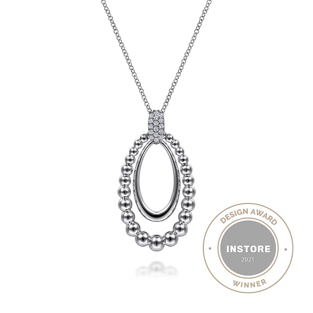 The Gabriel & Co 925 Sterling Silver White Sapphire Pendant Necklace (Serial No: S17) features a beautiful pendant from the Bujukan Collection. This elegant piece boasts an outer loop of small metallic beads encircling a smooth, oval inner loop. The pendant is suspended from a fine chain, and proudly displayed beside it is the "Design Award Instore 2021 Winner" badge.