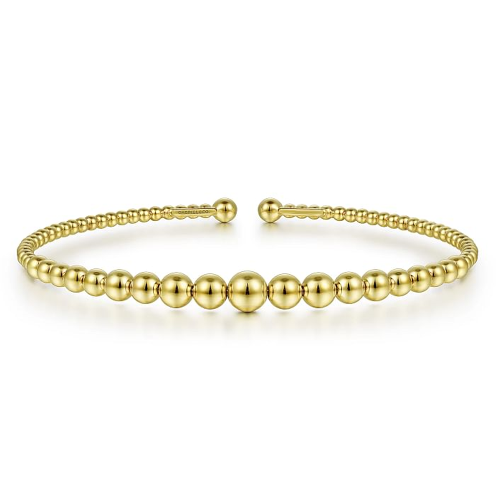 This stunning 14K Yellow Gold Bujukan Open Bangle by Gabriel & Co features a beautiful design of small and large alternating round beads. Presented against a plain white background, this elegant bracelet boasts a minimalist open front design.