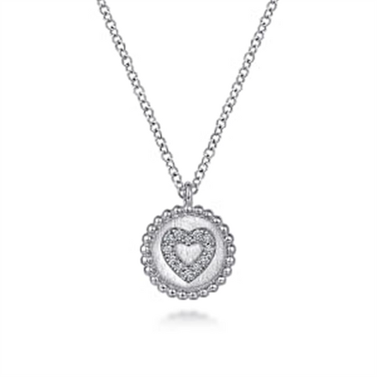 Introducing the Gabriel & Co 925 Sterling Silver Bujukan Diamond Heart Pendant Necklace, a delicate piece featuring a circular pendant with a raised heart design at its center, encrusted with sparkling small diamonds. This stunning necklace also boasts a border of evenly spaced beads, adding texture to the overall design from the Bujukan Collection.