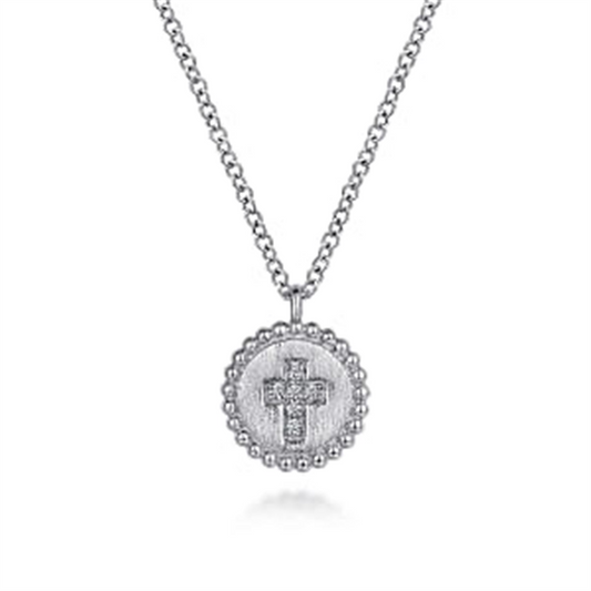 Introducing the Gabriel & Co 925 Sterling Silver Bujukan Diamond Cross Pendant Necklace. This exquisite piece from the Bujukan Collection features a round pendant with a beaded edge design, adorned with an engraved diamond cross at its center and small sparkling stones. The necklace includes a simple yet elegant silver link chain, all beautifully showcased against a white background.