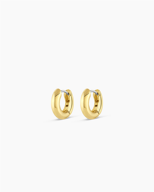 A pair of Gorjana Lou Huggies, 18k gold plated with a smooth, polished finish, are displayed against a plain white background.