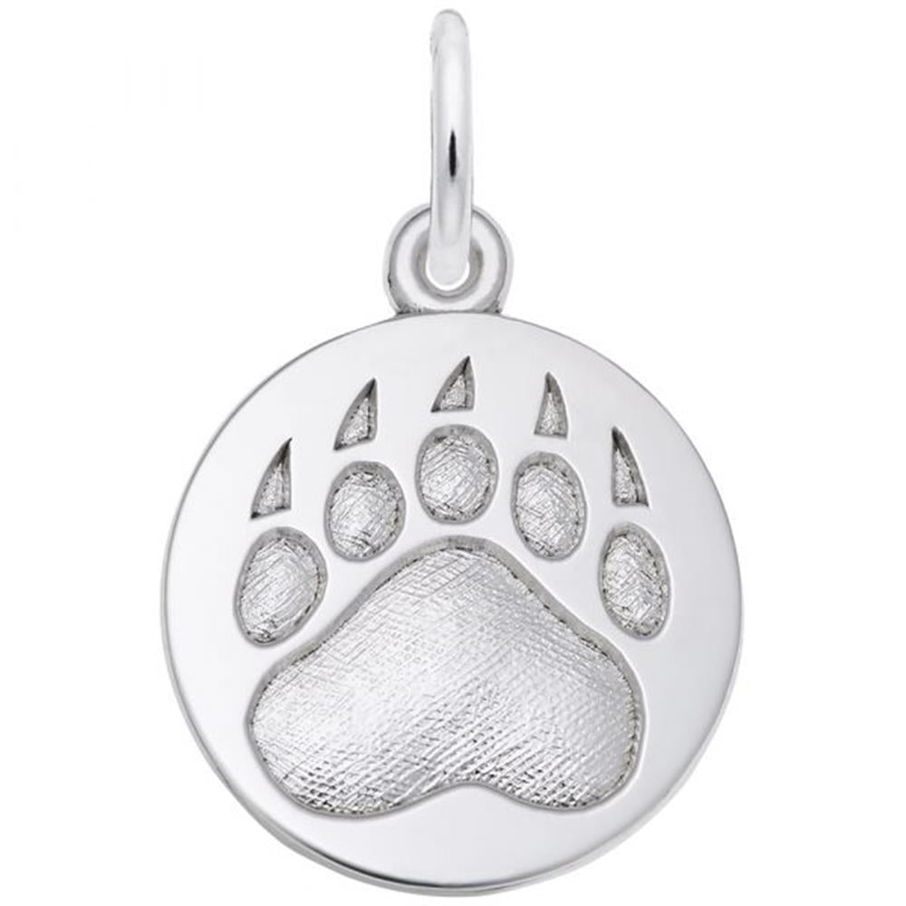 A silver circular pendant from Rembrandt Charms, featuring an engraved bear paw print design, is shown. The Bear Paw Print Charm in Sterling Silver has a glossy finish with textured details on the paw print and a small loop at the top for attaching to a chain or bracelet. It’s perfect for those who cherish wilderness jewelry.