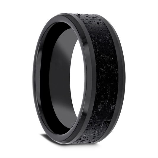 A close-up view of the Thorsten VESUVIUS Men’s Polished Black Ceramic Wedding Band showcases a textured, slightly raised black and gray lava rock stone inlay in the center, surrounded by smooth, polished beveled edges. The ring's surface is matte with a rugged, stone-like appearance.