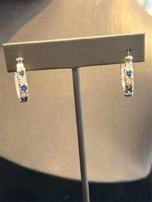Ryan Gems' 14k white gold Diamond and Sapphire Hoops, featuring alternating blue and clear stones, are displayed on a stand against a neutral background.