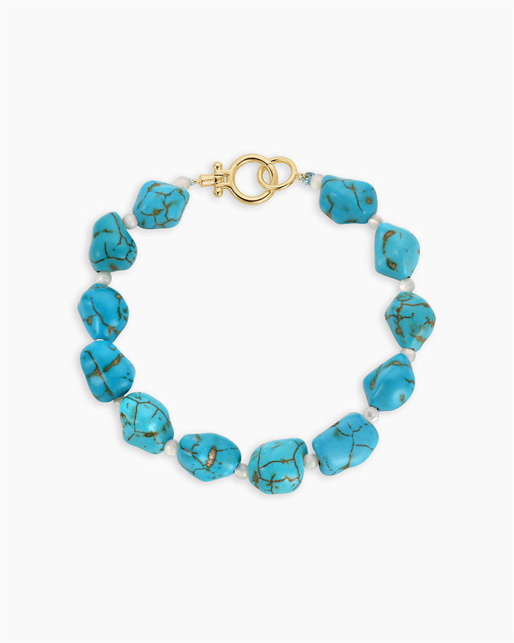 The Gorjana Turquoise Cove Bracelet features irregular turquoise stones with small white beads and a gold toggle clasp, capturing timeless turquoise jewelry style.