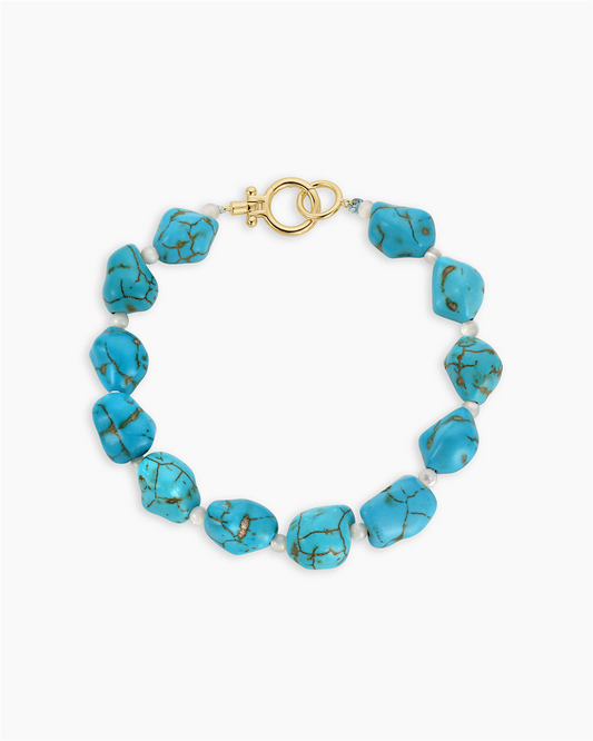 The Gorjana Turquoise Cove Bracelet features irregular turquoise stones with small white beads and a gold toggle clasp, capturing timeless turquoise jewelry style.