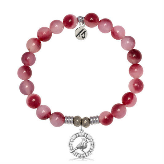The T Jazelle Cherry Jade Gemstone Bracelet features round pinkish-red stones, silver spacer beads, a sterling silver "15" charm, and a circular pendant with a white cardinal design.