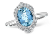 The Allison Kaufman Aquamarine and Diamond 14k White Gold Ring showcases an oval-cut aquamarine gemstone encircled by a stunning diamond halo, all set on a sleek band, offering an elegant and luxurious appearance.