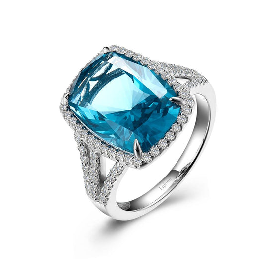 The Paraiba Tourmaline Halo Ring by Lafonn showcases a stunning, large cushion-cut simulated Paraiba Tourmaline at its center, encircled by a dazzling halo of diamonds. The sterling silver band, bonded with platinum and accented with additional diamonds, enhances the intricate and elegant design.
