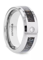 The COLTON Tungsten Carbide Ring by Thorsten showcases a polished silver band with a dark wood and deer antler inlay, accented by a small, round diamond set into the surface. The inside of the 8mm band features engraved text detailing the ring's material.