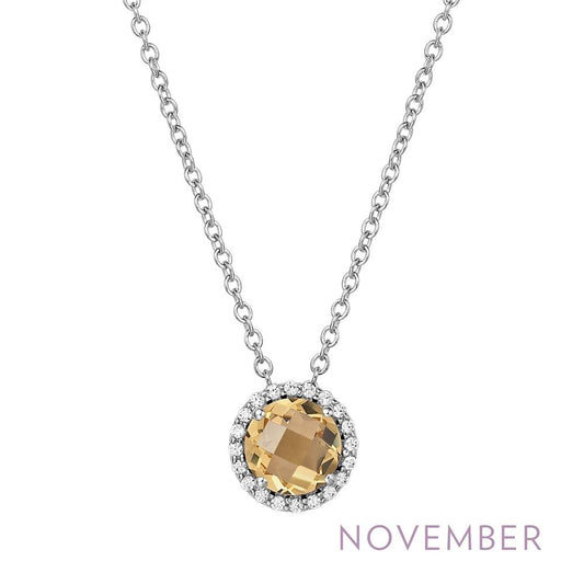 The "November Birthstone Necklace" by Lafonn showcases a stunning round yellow gemstone, symbolizing the November birthstone, encircled by sparkling clear stones. This elegant pendant is suspended from a delicate silver chain. The word "November" is highlighted in purple text at the bottom right corner of the image.