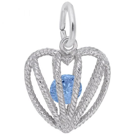 The Embraced with Love December Stone Charm by Rembrandt Charms showcases a sterling silver, heart-shaped pendant adorned with intricate wire detailing and centering a vibrant blue topaz gemstone, perfect for December birthdays. It features a loop at the top for easy attachment to a chain or bracelet.