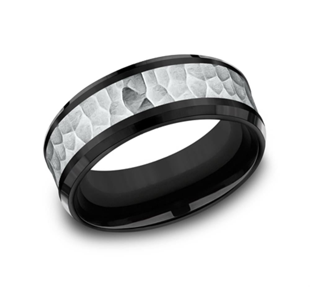 The Black and Grey Textured Band by Benchmark Rings / Amarra Stone is a striking black titanium ring featuring a hammered 14K white gold inlay encircling the band. The ring boasts a smooth black inner surface and polished edges, delivering a modern and stylish appearance. The inlay’s textured, irregular pattern enhances the striking contrast.